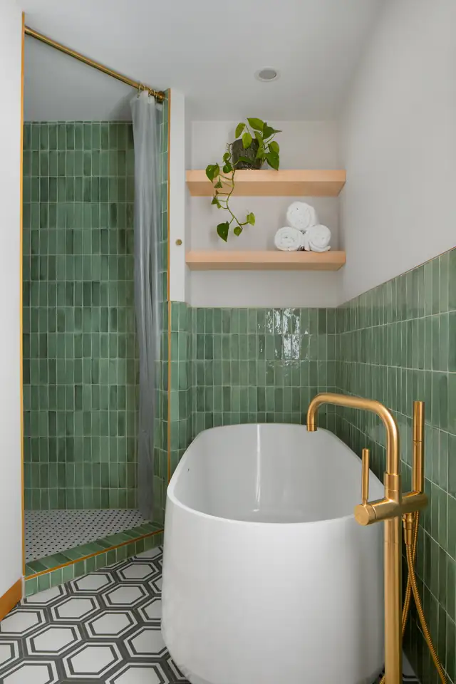 Holly Road bathroom remodel with green glazed wall tile, freestanding tub, brass floor-mounted tub filler and hexagon floor tile