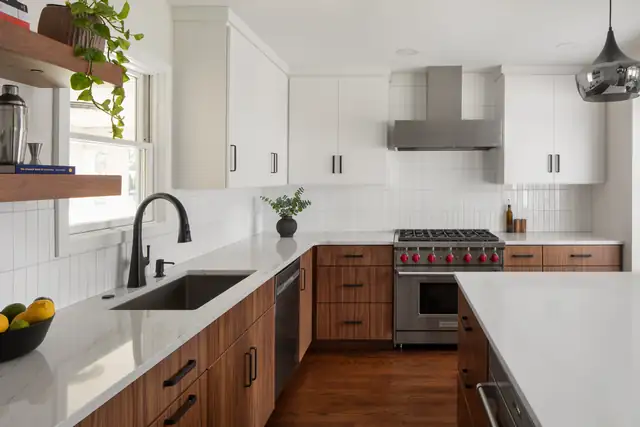 Kitchen with walnut base cabinets, white quartz counters, white upper cabinets and stainless range hood on Mohawk Road