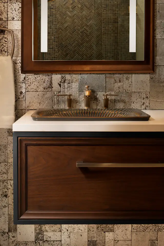 Pawnee Drive bathroom vanity with hammered copper sink, dark wood drawer front and tumbled stone tile wall