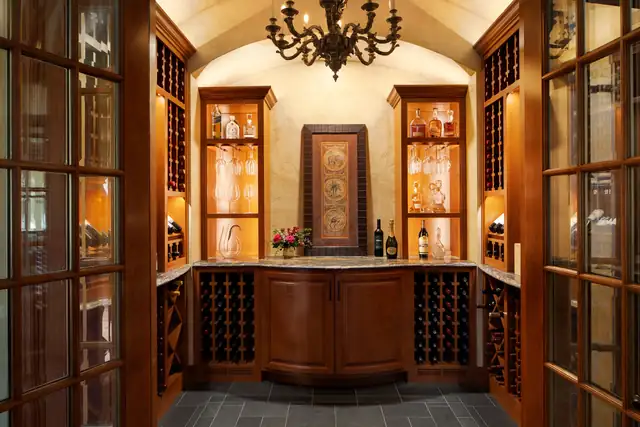 Custom wine cellar with arched ceiling, wood wine racking, lighted display cabinets and glass-paned doors